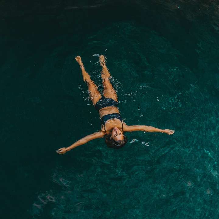 женщина в черном бикини плавает в воде онлайн-пазл