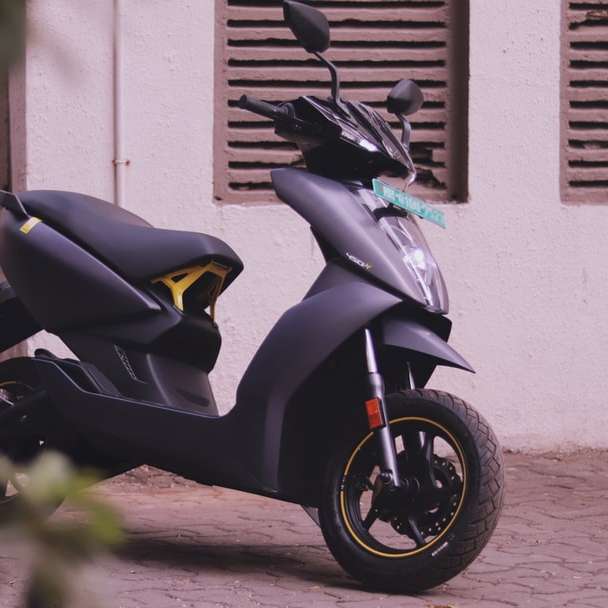 schwarzer und gelber Motorroller geparkt neben weißer Wand Schiebepuzzle online