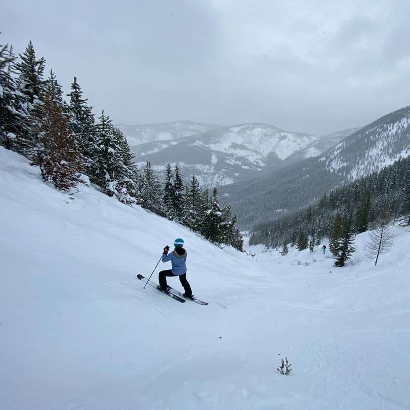човек в бяло яке и черен панталон, каращ ски остриета онлайн пъзел