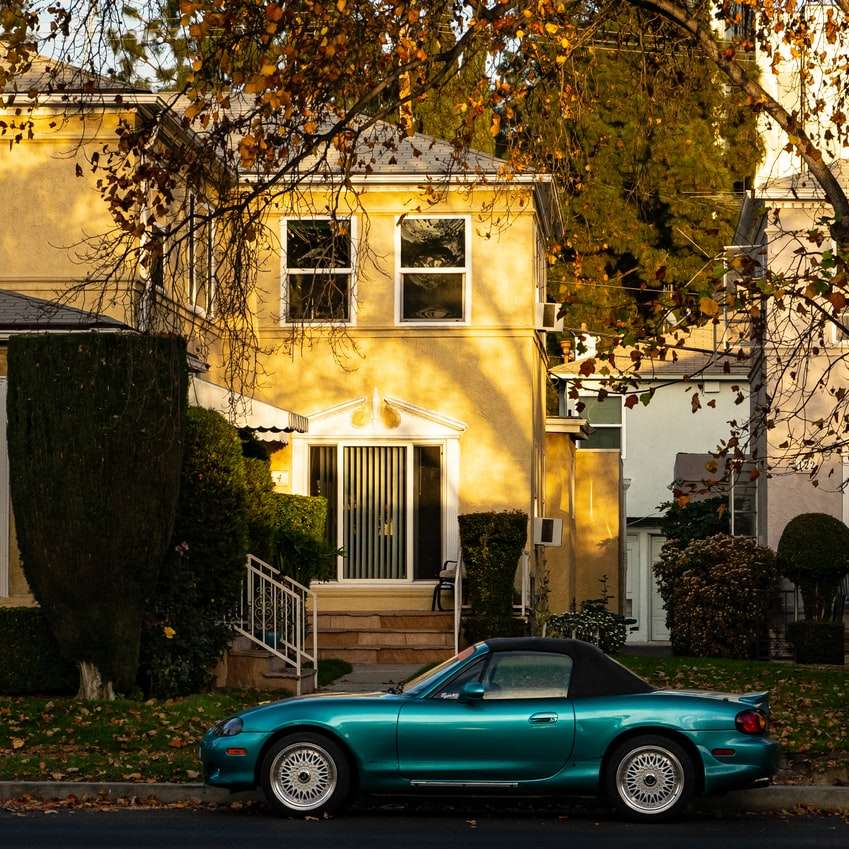 blauwe coupé geparkeerd naast bruin betonnen gebouw schuifpuzzel online
