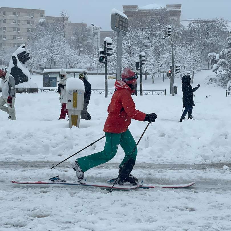 människor i röd jacka och byxor som spelar skidor Pussel online