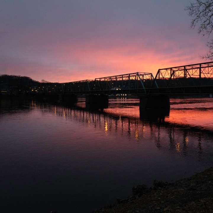 σιλουέτα της γέφυρας πάνω από το νερό κατά το ηλιοβασίλεμα online παζλ