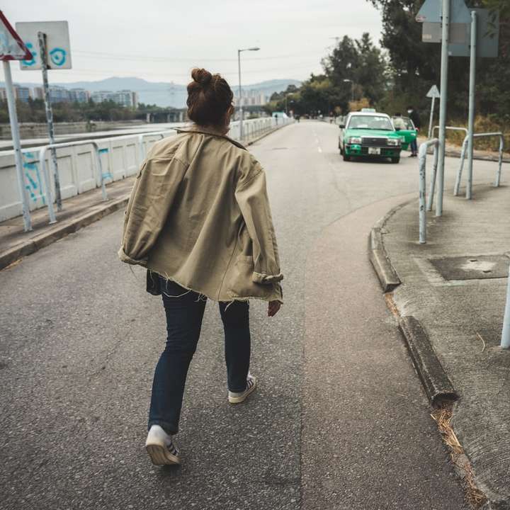 kvinna i brun kappa och blå jeansjeans glidande pussel online