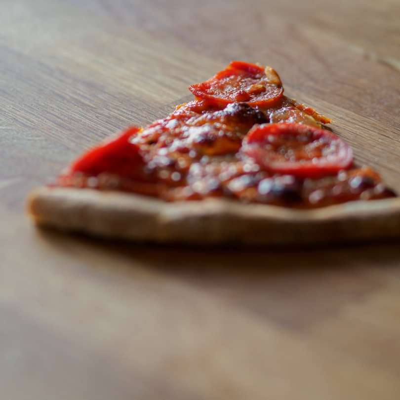 нарізану піцу на коричневий дерев'яний стіл онлайн пазл