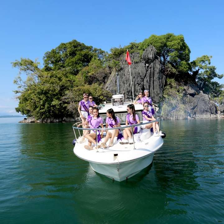 lidé na bílém člunu na vodě během dne online puzzle