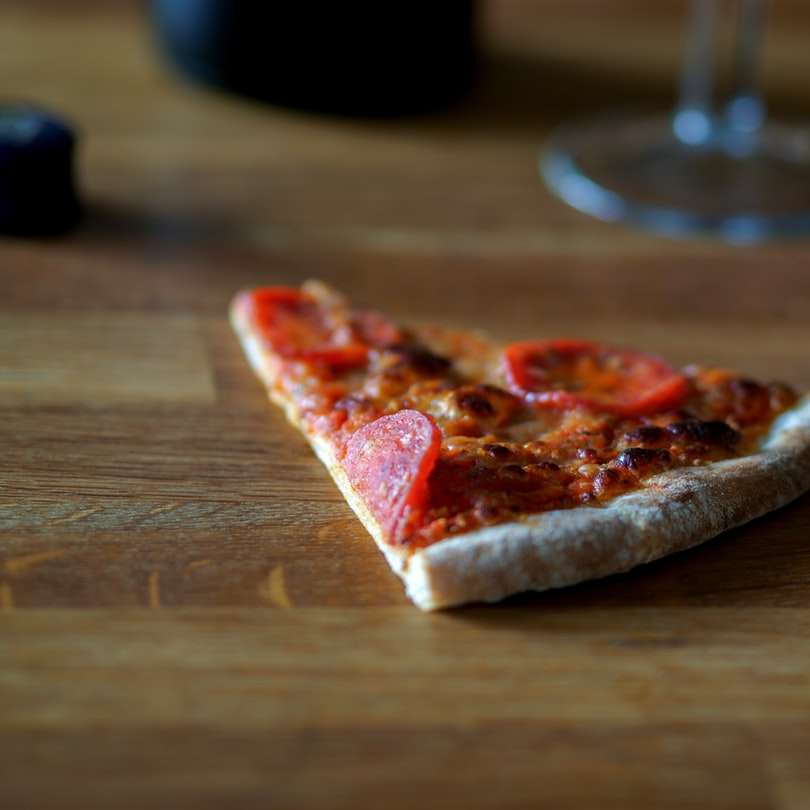 geschnittene Pizza auf braunem Holztisch Online-Puzzle