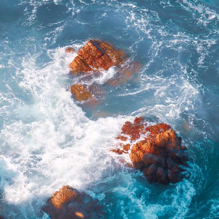 formação de rocha marrom em corpo d'água durante o dia puzzle deslizante online
