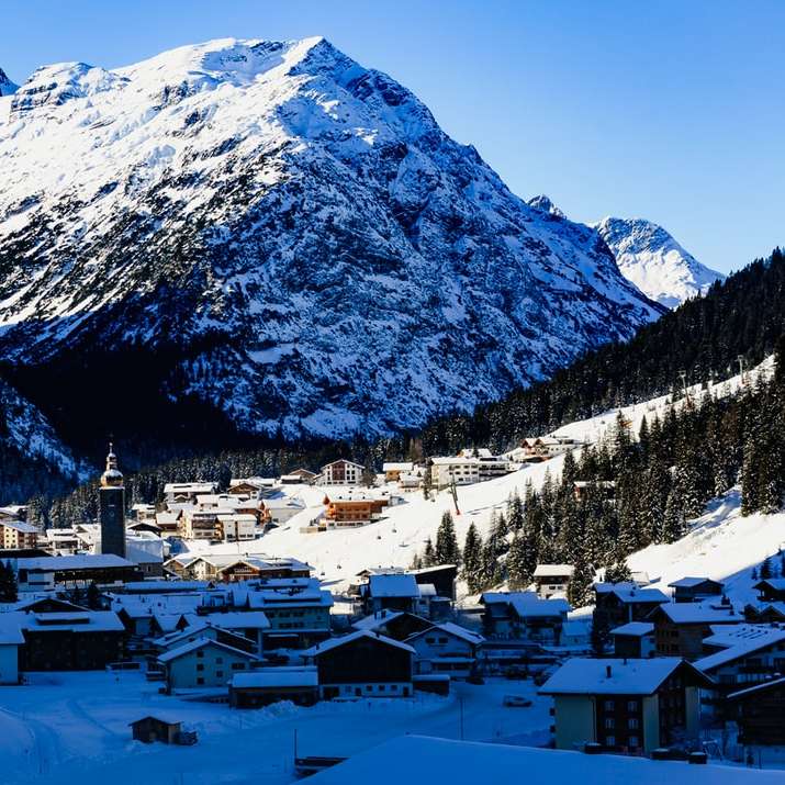 białe i brązowe domy w pobliżu góry pokrytej śniegiem puzzle przesuwne online