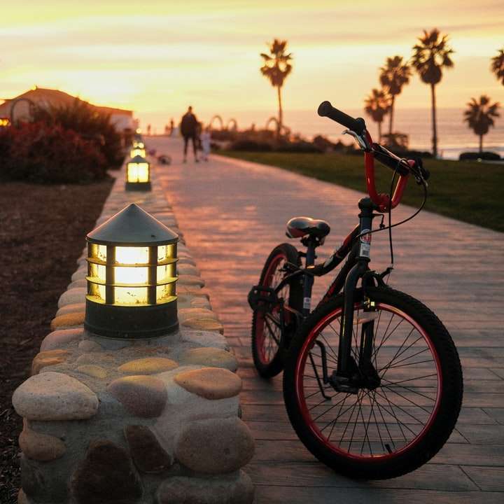 zwarte en rode fiets geparkeerd naast zwarte lantaarnpaal schuifpuzzel online