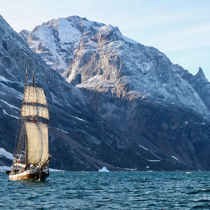 коричнево-белая лодка на море у горы в дневное время раздвижная головоломка онлайн