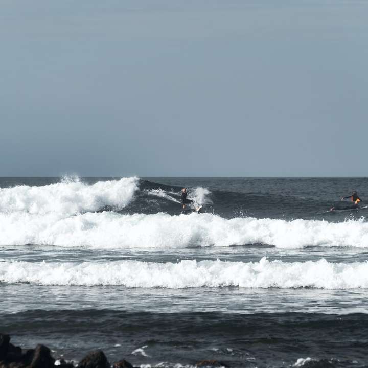 хора, които сърфират на морски вълни през деня плъзгащ се пъзел онлайн
