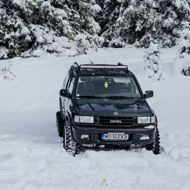 SUV noir sur sol couvert de neige pendant la journée puzzle en ligne
