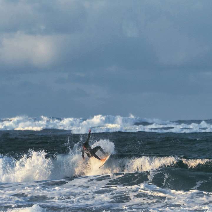 osoba, surfování na mořských vlnách během dne online puzzle