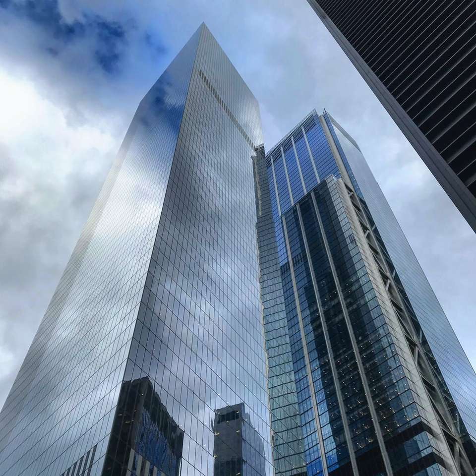 fotografia ad angolo basso di un edificio alto sotto il cielo blu puzzle online