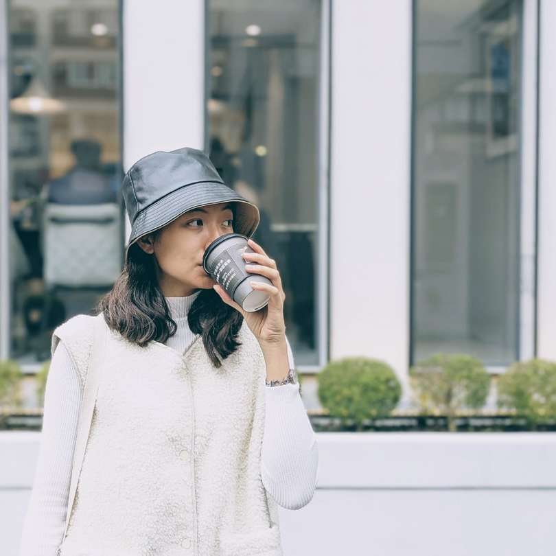 femeie în pulover alb purtând șapcă neagră puzzle online