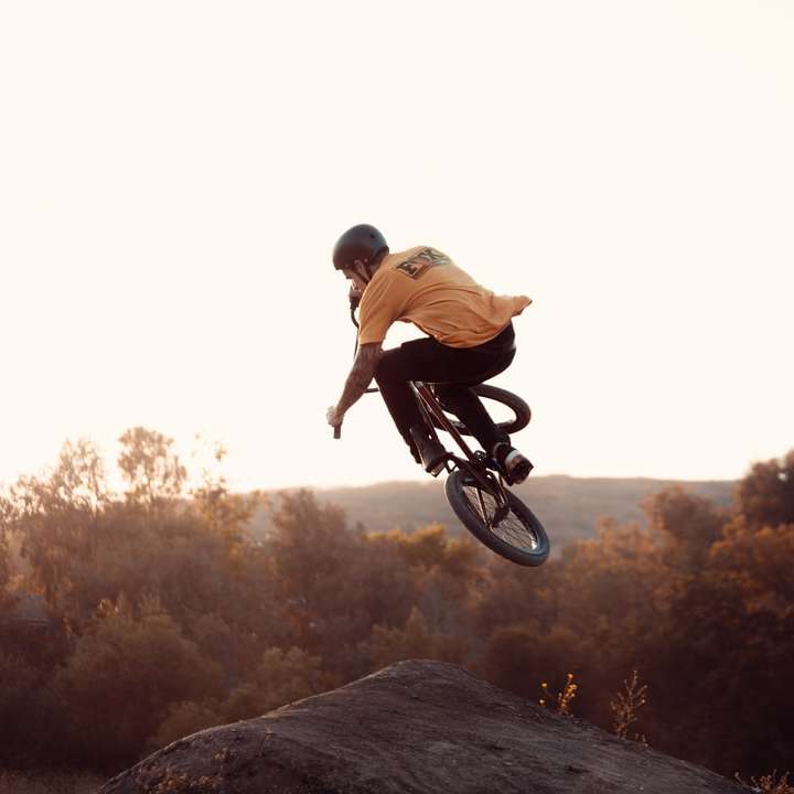 茶色の岩の上で自転車に乗る茶色のシャツの男 スライディングパズル・オンライン