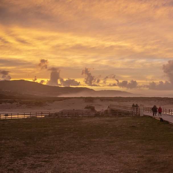 pessoas caminhando na praia durante o pôr do sol puzzle deslizante online