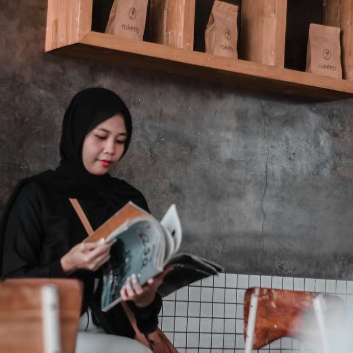 femeie în hijab negru care deține cana albă din ceramică alunecare puzzle online
