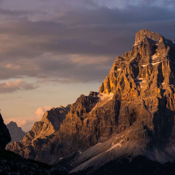 bruine rotsachtige berg onder bewolkte hemel overdag online puzzel