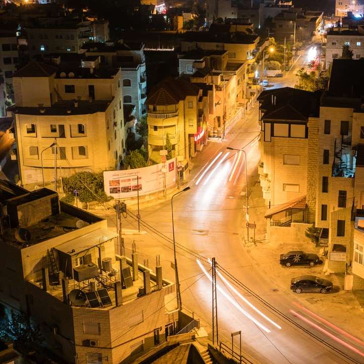 αυτοκίνητα στο δρόμο κοντά σε κτίρια κατά τη διάρκεια της νύχτας online παζλ