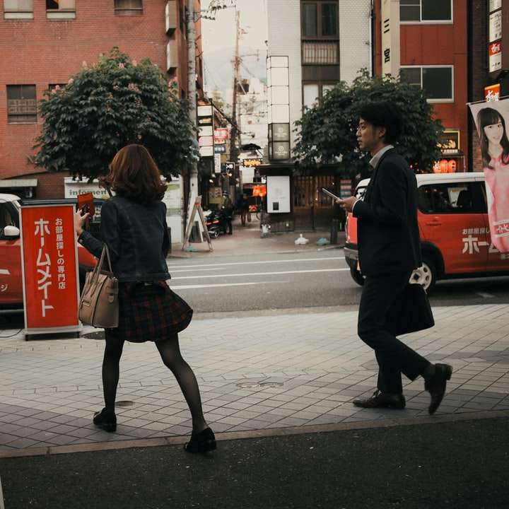 жена в черно яке, ходеща през тротоара през деня плъзгащ се пъзел онлайн