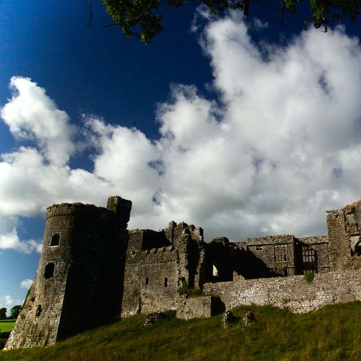 szary betonowy zamek pod błękitne niebo i białe chmury puzzle przesuwne online