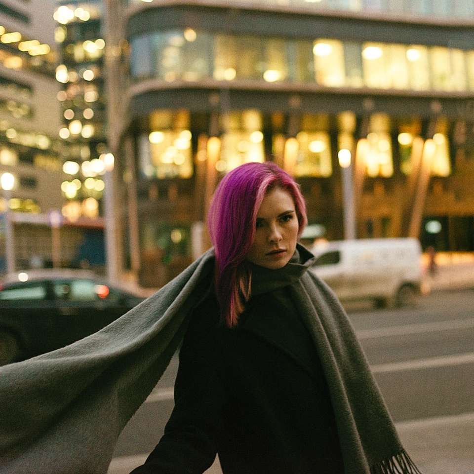 vrouw in zwarte jas die 's nachts op straat staat online puzzel