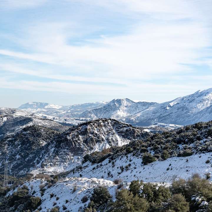 montanhas cobertas de neve sob céu azul durante o dia puzzle deslizante online