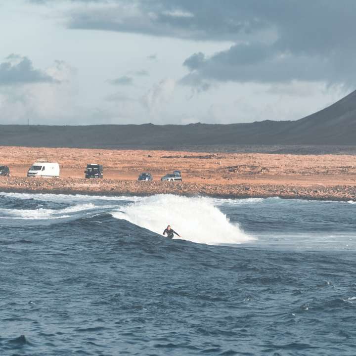 persona que practica surf en las olas del mar durante el día puzzle deslizante online