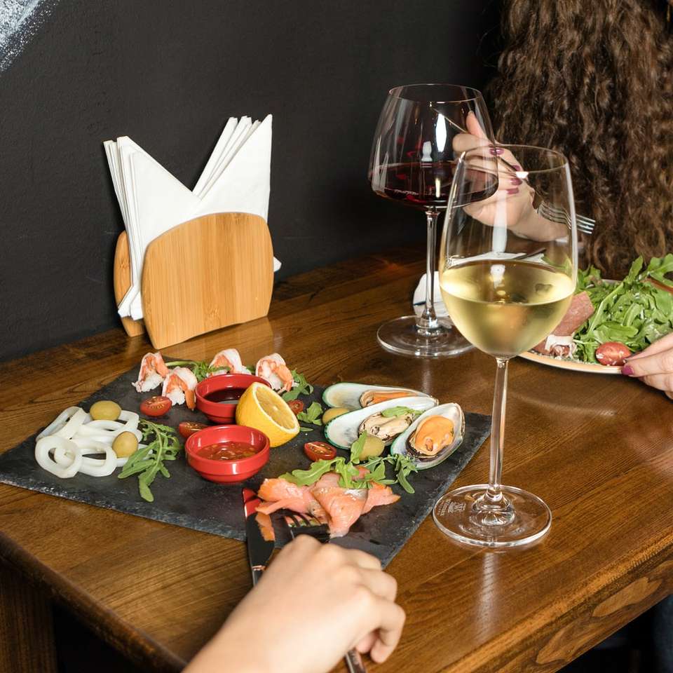 Copa de vino transparente sobre mesa de madera marrón rompecabezas en línea
