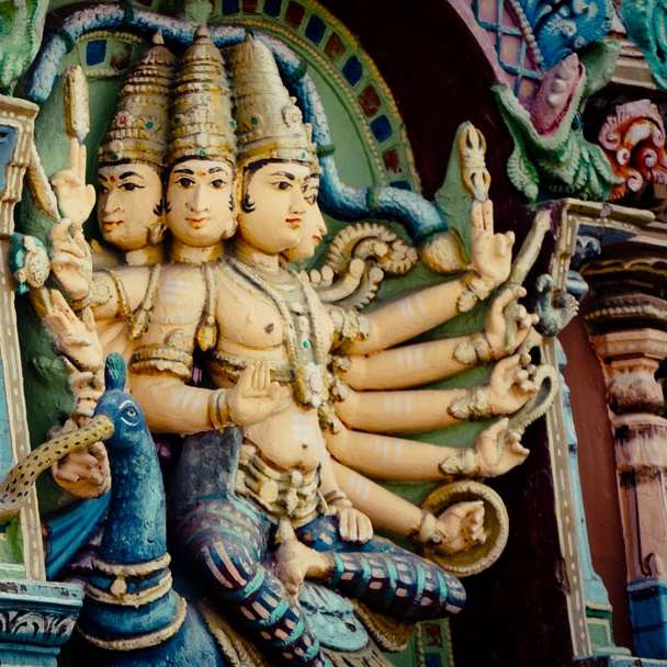 statua in oro divinità indù su mensola in legno blu e marrone puzzle online