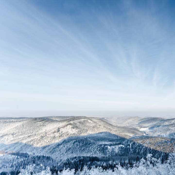 munte acoperit de zăpadă sub cerul albastru în timpul zilei alunecare puzzle online