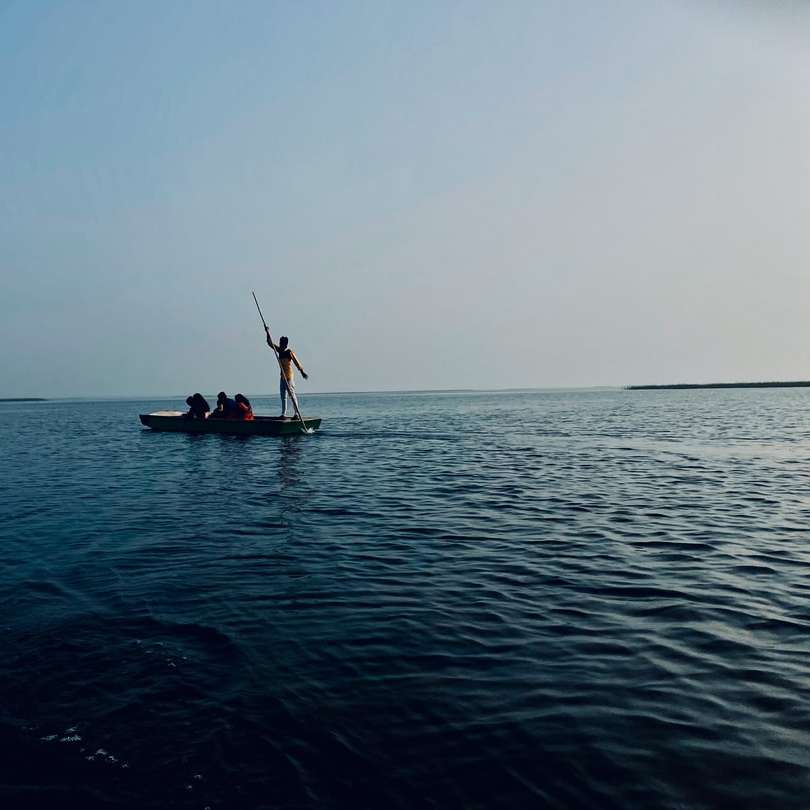 2 personer som rider på båt till sjöss under dagtid glidande pussel online
