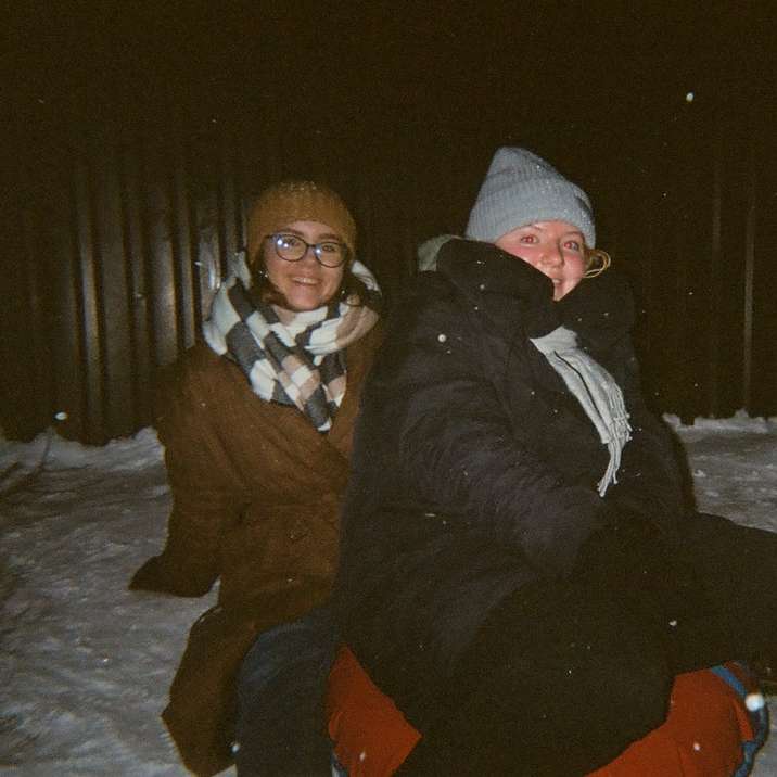 man and woman sitting on snow covered ground sliding puzzle online