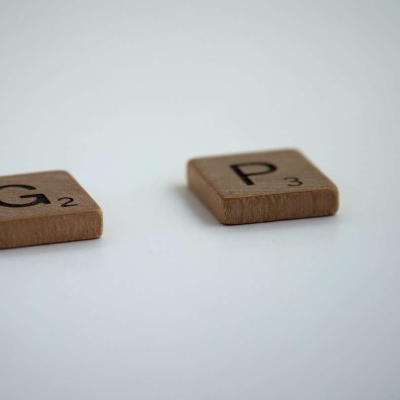 Dados de madera marrón sobre superficie blanca puzzle deslizante online