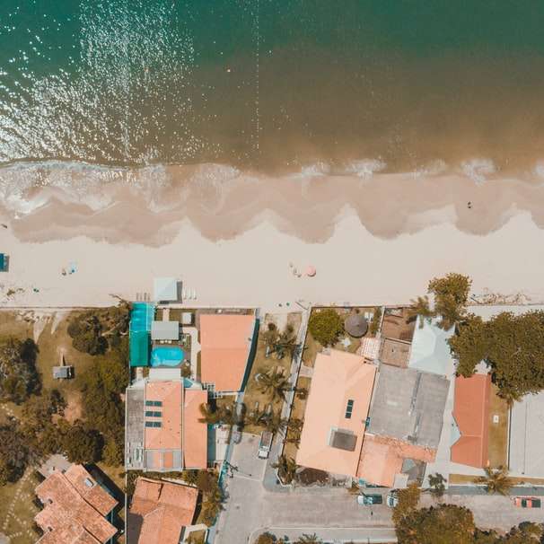 Casas de hormigón blanco y marrón cerca del mar durante el día puzzle deslizante online