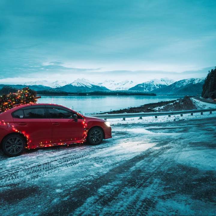 czerwony sedan na ziemi pokrytej śniegiem w ciągu dnia puzzle online
