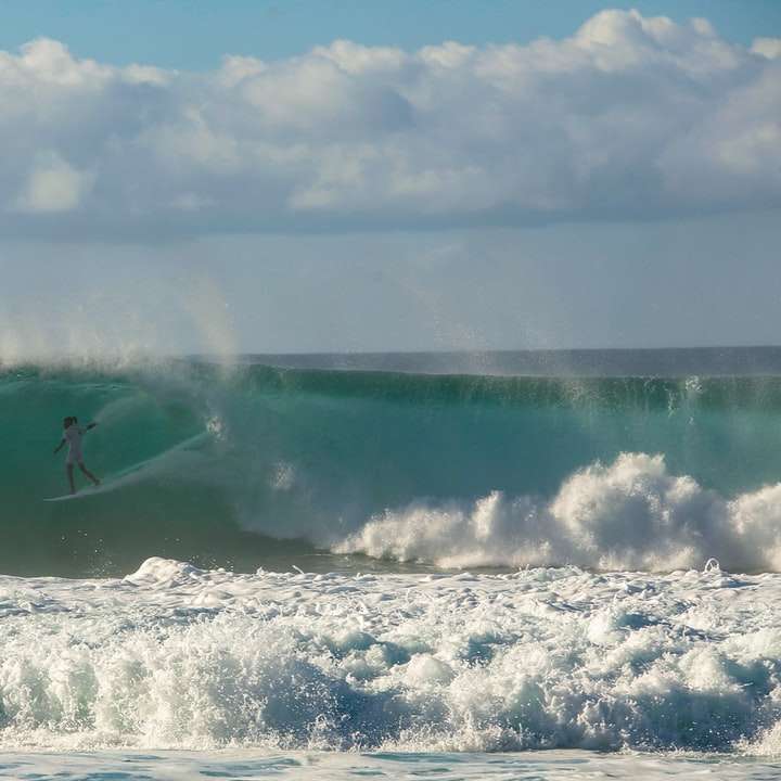 persona que practica surf en las olas del mar durante el día rompecabezas en línea