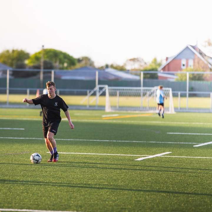 мъж в черна риза, играещ футбол през деня онлайн пъзел