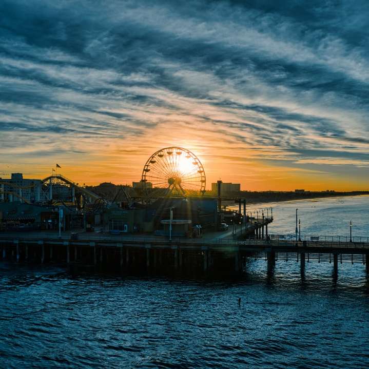 Riesenrad am Dock während des Sonnenuntergangs Schiebepuzzle online