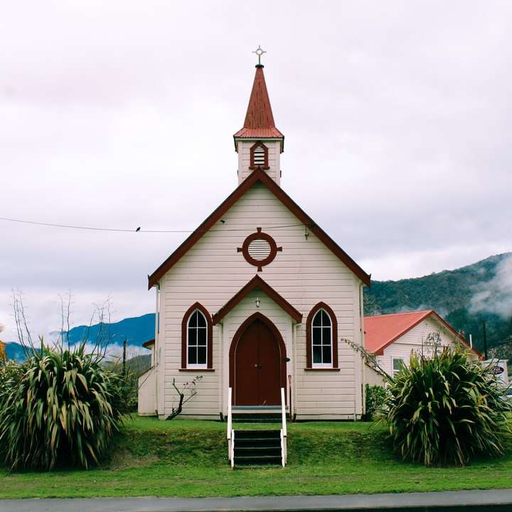 Iglesia blanca y marrón cerca de palmeras bajo nubes blancas rompecabezas en línea