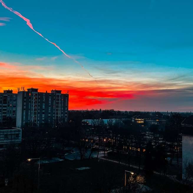 panorama města pod oranžovou a modrou oblohou při západu slunce online puzzle