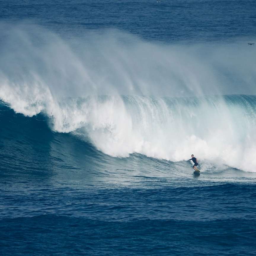 човек, който сърфира на морски вълни през деня плъзгащ се пъзел онлайн