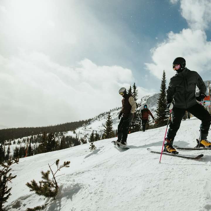 Hombre de chaqueta negra y pantalón azul cabalgando sobre palas de esquí puzzle deslizante online