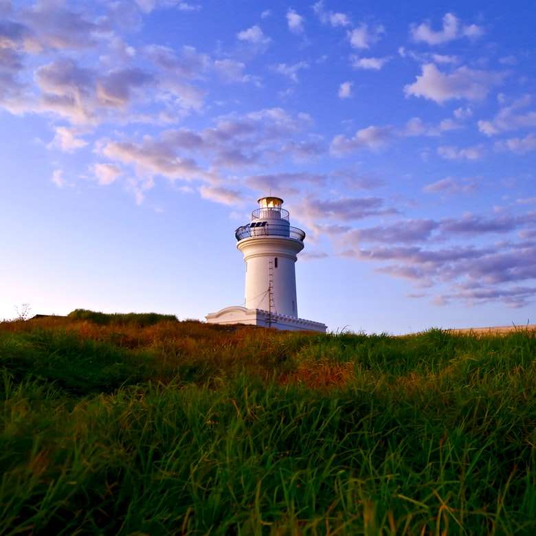 white lighthouse under blue sky and white clouds sliding puzzle online