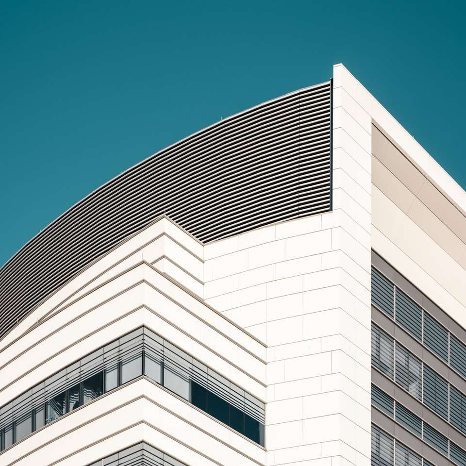 biały betonowy budynek pod błękitnym niebem w ciągu dnia puzzle przesuwne online