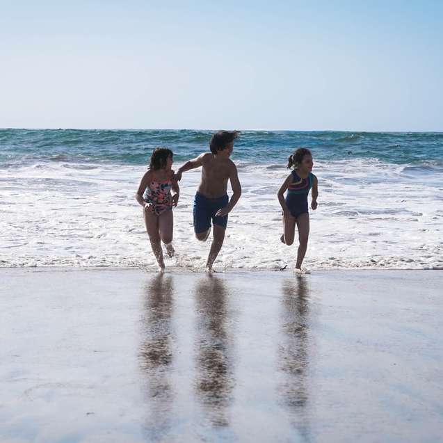 3 жени в черно бикини, стоящи на плажа през деня онлайн пъзел