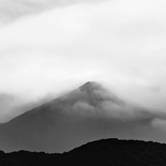 Foto en escala de grises de la montaña bajo el cielo nublado rompecabezas en línea