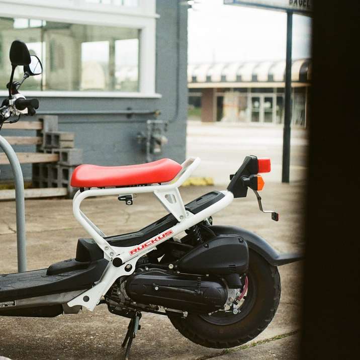 бял и червен мотоциклет пред червен и черен стол плъзгащ се пъзел онлайн