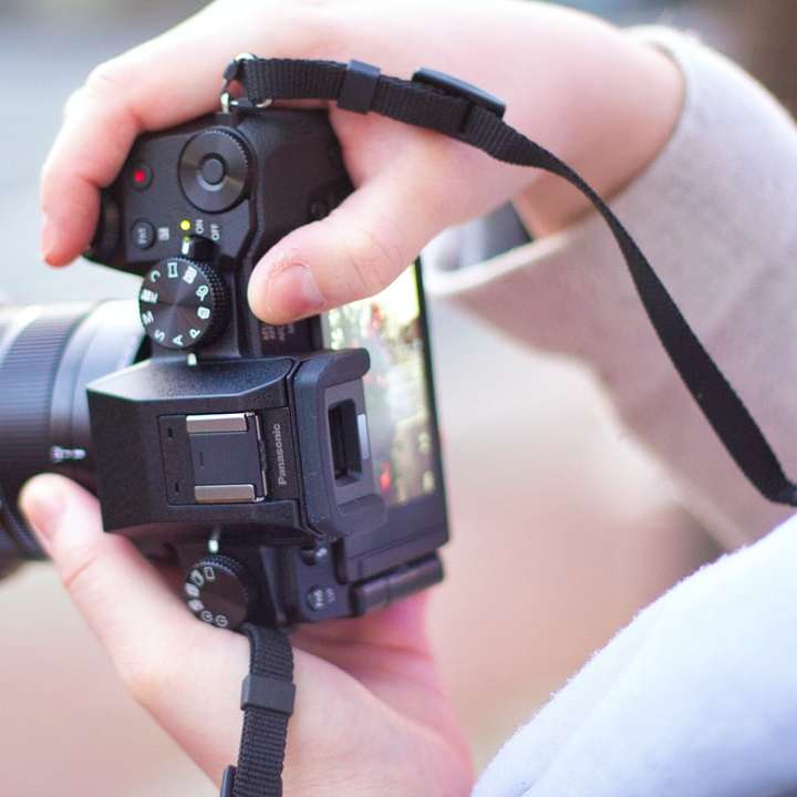 άτομο που κρατά μαύρη κάμερα DSLR συρόμενο παζλ online